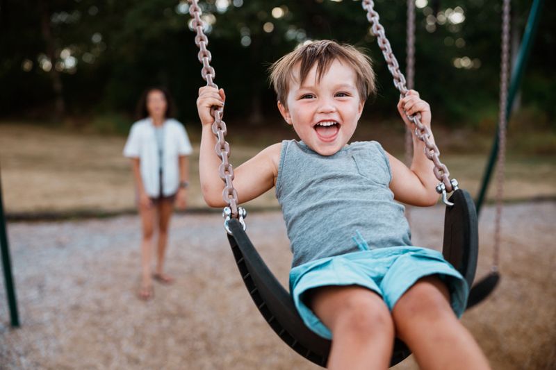 Smiling child playing in a sunlit park during a joyful photography session