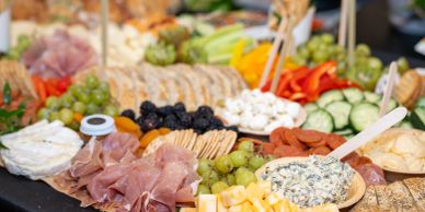 A diverse charcuterie board with meats, cheeses, and fruits.