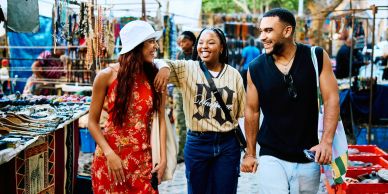 Three friends walking happily in a market.