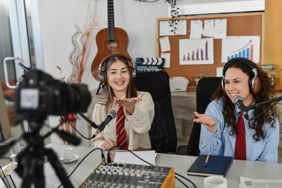 Two women recording a podcast together with microphones and headphones.