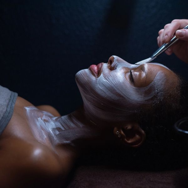 Woman receiving a facial mask treatment.