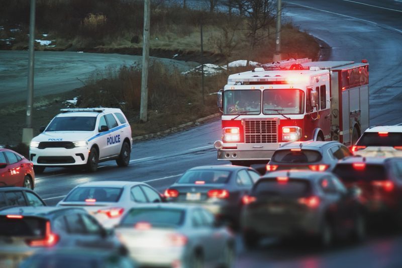 A fire truck makes its way through rush hour traffic while enroute to an emergency.