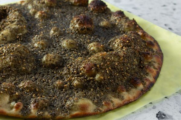 Close-up of a za'atar flatbread with sesame seeds and olive oil.