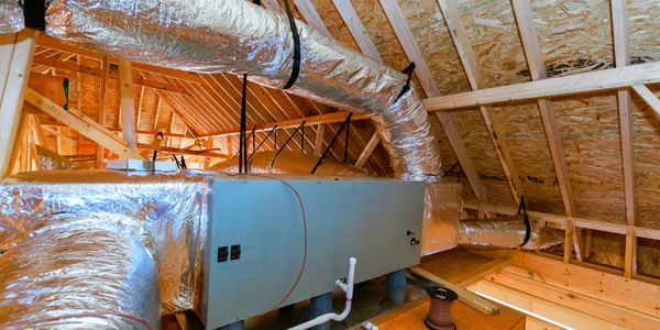 Modern HVAC system installed in an attic with exposed wooden beams.
