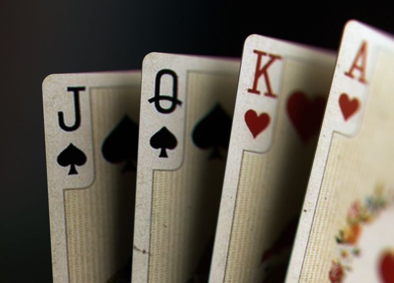 Closeup image of four vintage playing cards featuring jack, queen, king, and ace on a dark background. Ideal for casino themes, poker content, luxury gaming designs - 3D render