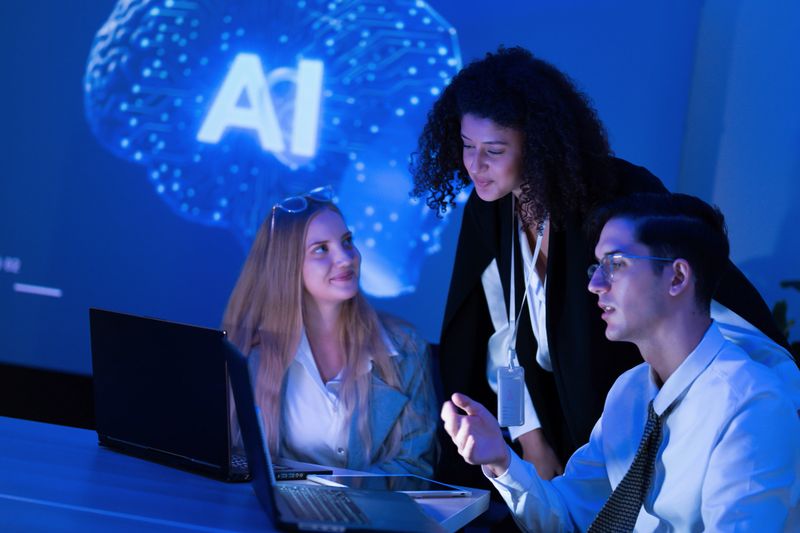 Three professionals discuss ideas and strategies for an artificial intelligence project in a contemporary office. A digital brain graphic highlights their focus.