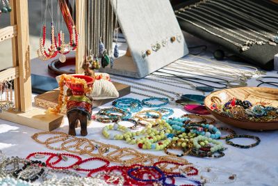 Colorful handmade jewelry displayed on a market table.