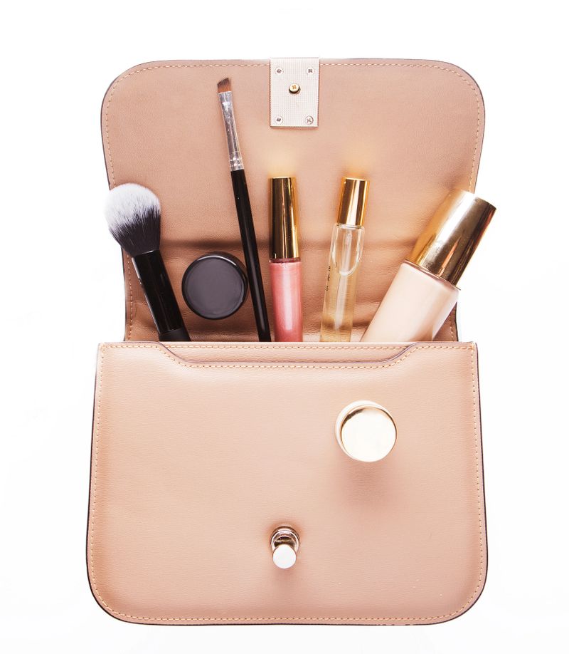 Makeup products with cosmetic bag on white background. Close up.