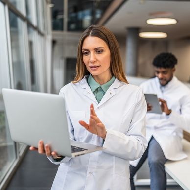 Female scientist using laptop in modern laboratory.