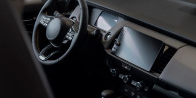 Modern car dashboard with touchscreen and steering wheel.
