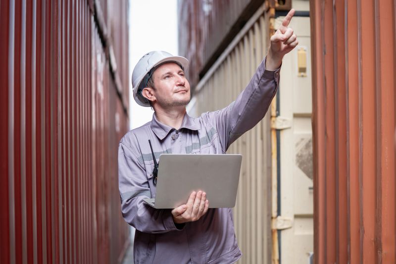 A logistics manager assesses container organization and efficiency in a busy shipping yard.