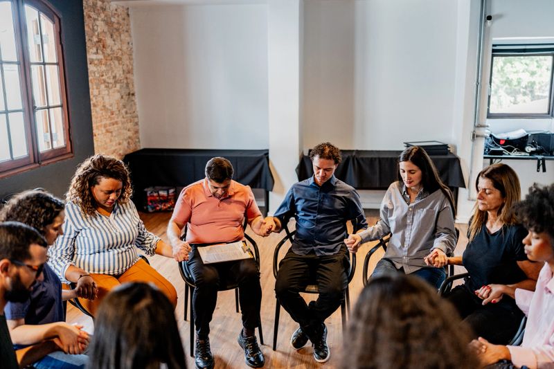 Participants praying on a therapy group
