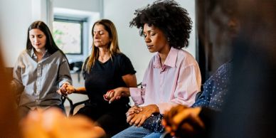 A group holding hands and meditating together.