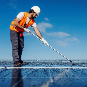 Trabajador limpiando paneles solares.