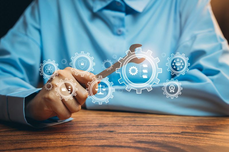 Automation concept. Hand holding wrench with digital gear interface, system optimization, workflow efficiency, smart factory, industrial technology, maintenance planning, digital transformation.