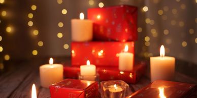Candlelit festive scene with red presents and bokeh lights.