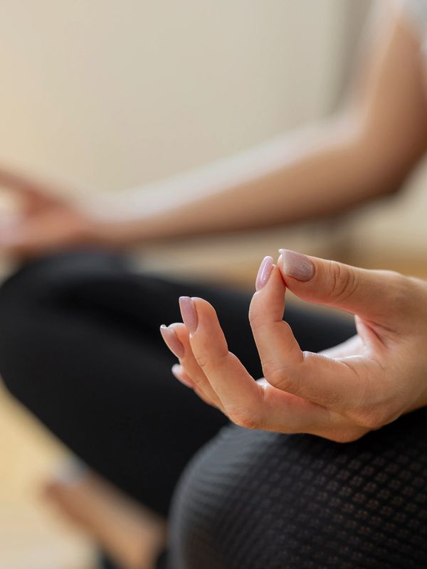 Close-up of a person meditating with hand in a mudra gesture.