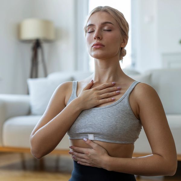Young woman practicing deep breathing or meditation at home.