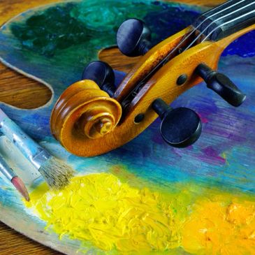 Violin scroll on colorful painter's palette with brushes.
