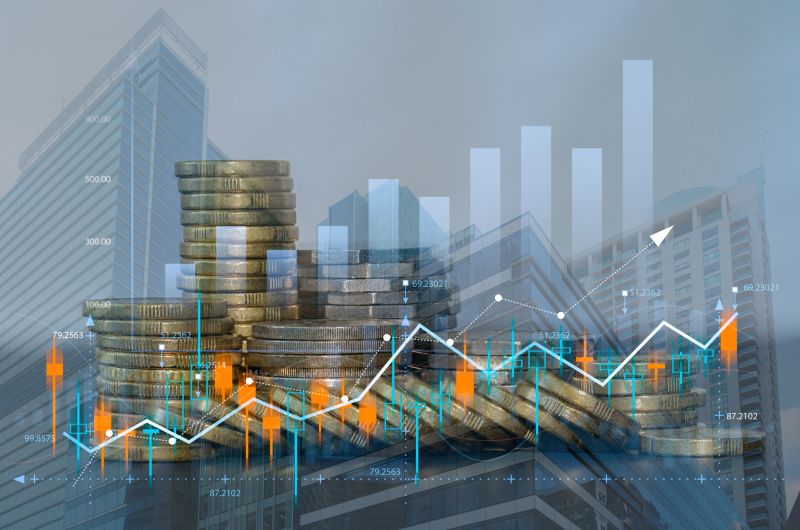 Stacked coins with upward financial chart and candlestick graph over city buildings. Concept of investment growth, stock market performance, wealth management, ROI and economic success
