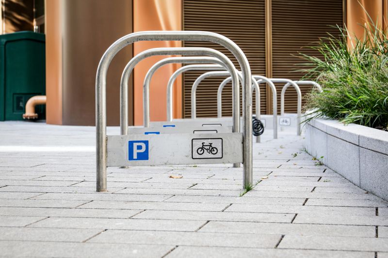P Parking Stand. Modern Urban Bicycle Rack Area on Paved Walkway Near Contemporary Building
