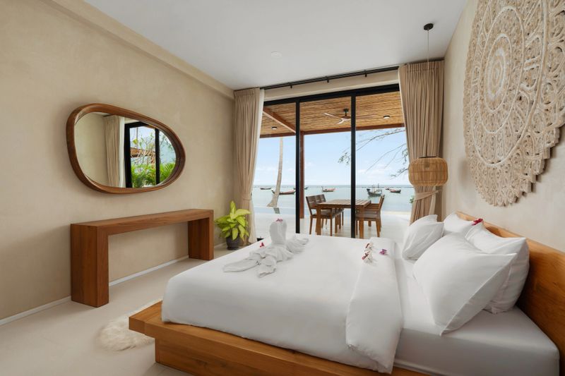Comfortable bedroom showing a king-size bed with white sheets and towels in a luxury villa.