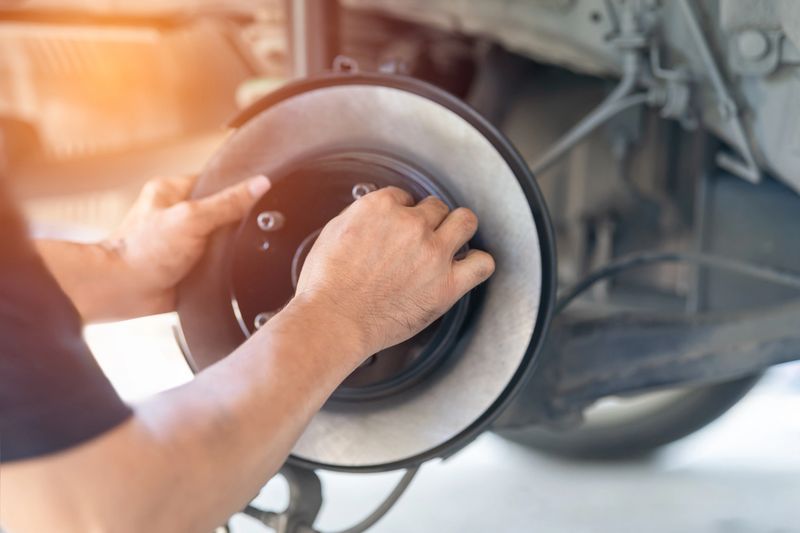 Car Disc Brake Service and Maintenance Concept, Auto Mechanic Replacing Brake Pads and Disc Rotor in Repair Garage, Vehicle Safety Inspection, Professional Automotive Repair with Copy Space