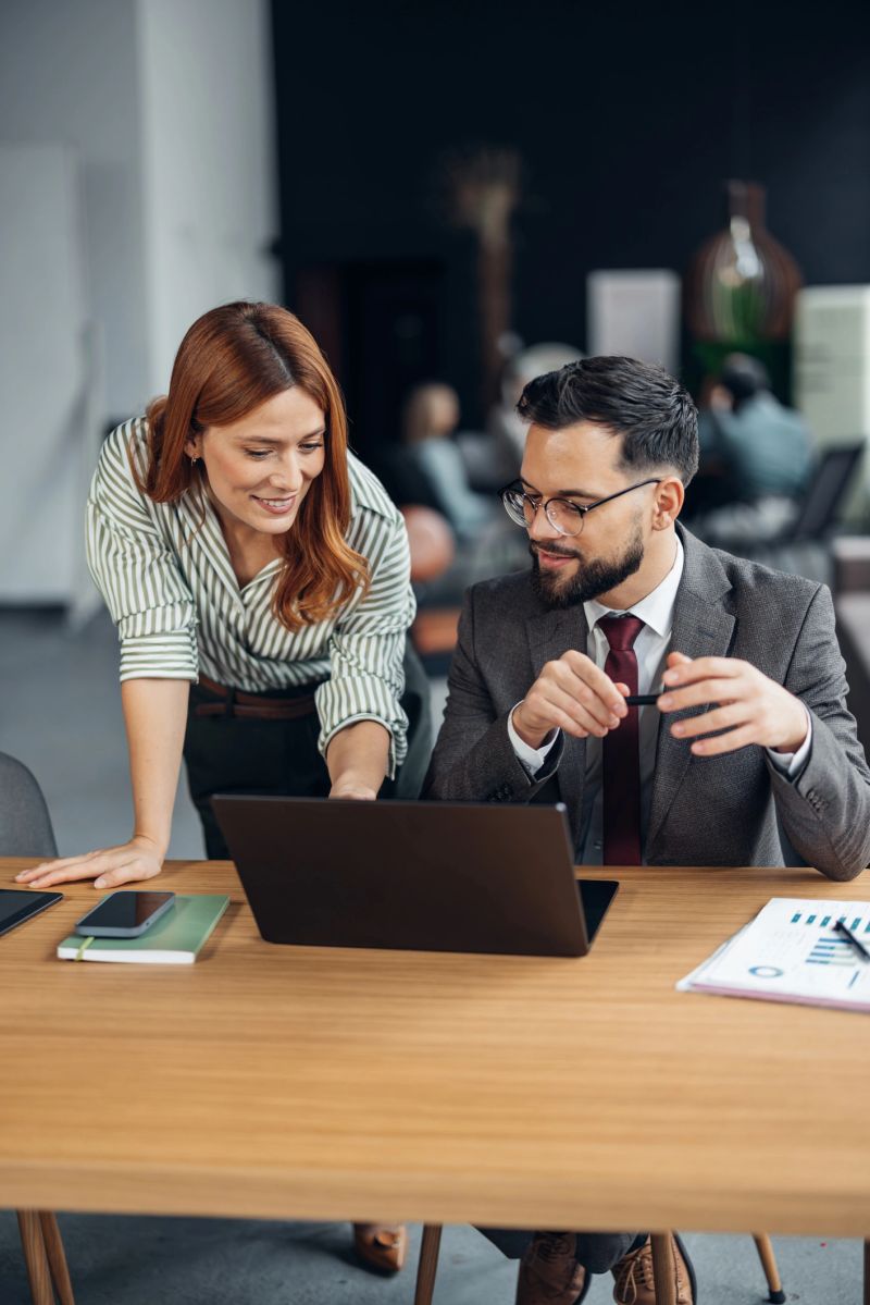 A vibrant scene showing professionals collaborating with digital tools in a modern office space, emphasizing teamwork, communication, and innovation in a corporate context.