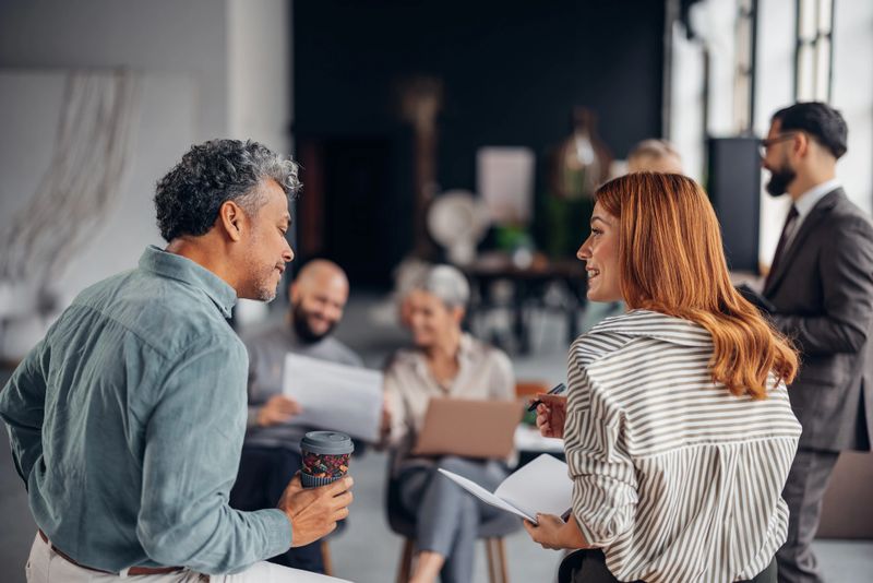 A diverse group of professionals engaged in a collaborative meeting, sharing ideas and discussing strategies in a modern, open office environment that promotes creativity and teamwork.
