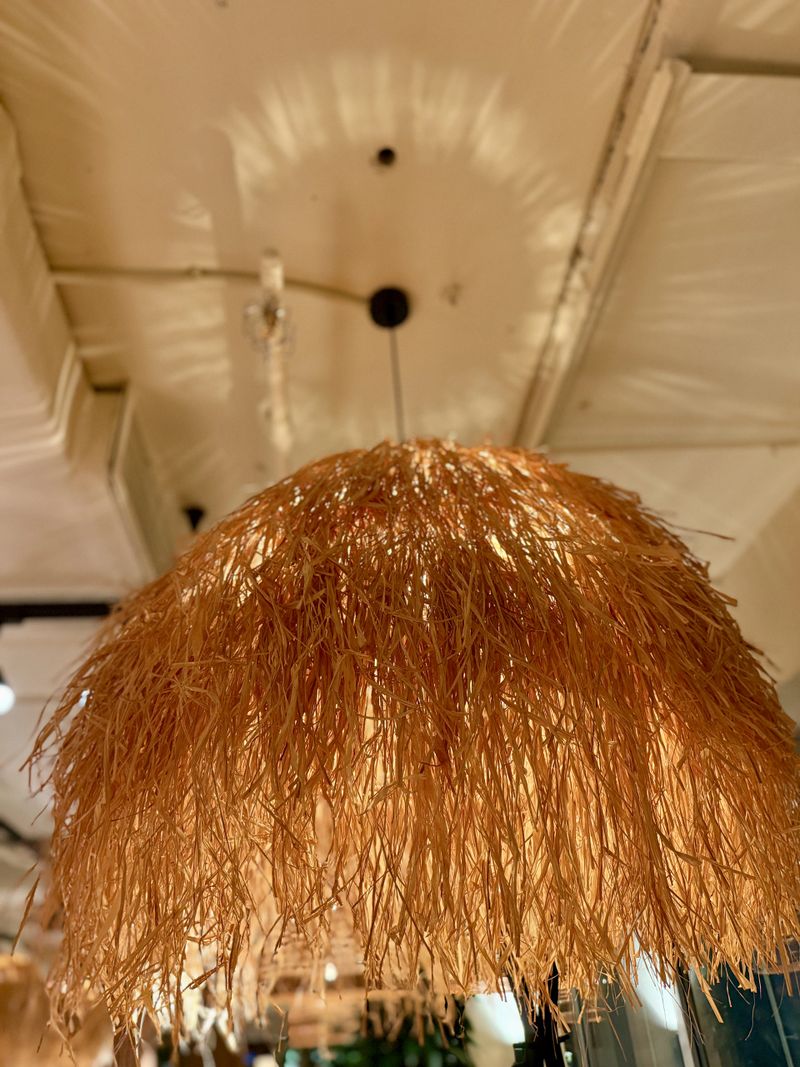 Warm Rattan Pendant Lamps Above Table, Casting Soft Golden Glow Over Wooden Table Setting With Woven Textures And Lush Plants, Modern Rustic Decor And Relaxed Evening Mood Perfect