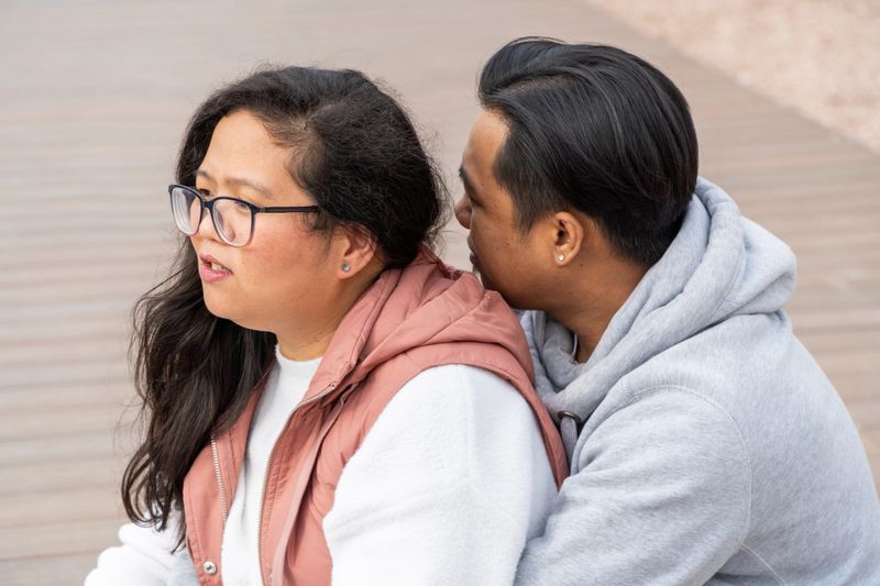 Asian man and woman on an romantic moment sitting on the dock