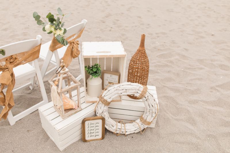 Soft Pastel Beach Wedding Decor with Burlap, Rustic White Wood, Rattan, Ivory-Colored Roses, Cream Stock Spray Flowers & Sage-Green Eucalyptus for a Modern Rustic Beach Wedding in Jupiter, Florida in December 2025.