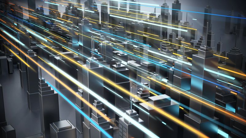 Tall buildings rise from the ground in a city skyline. Bright lights move through the scene in various colors, creating a dynamic visual at night.