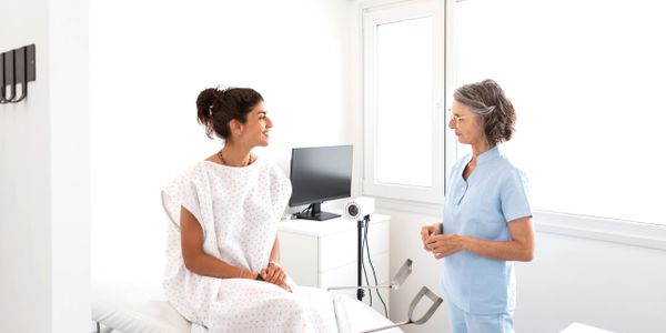 Patient and healthcare professional discussing in a bright medical room.