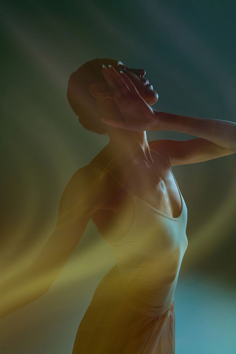 Expressive dancer silhouette with warm blurred streaks and graceful emotional pose. Concept of dance wellness ads, emotional branding, poster visuals, creative marketing assets.