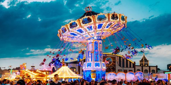 Colorful swing ride lit up at a crowded carnival.