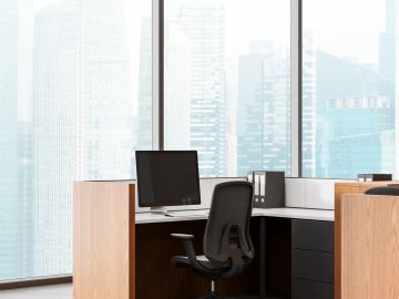 Modern office cubicle with a computer and ergonomic chair.
