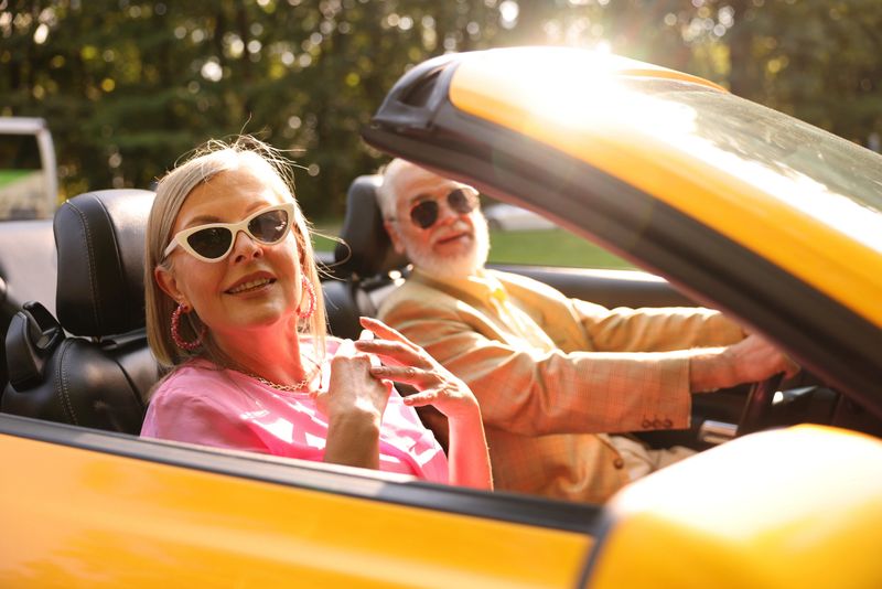 Senior couple enjoying cabriolet ride in city, selective focus