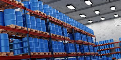 Rows of blue barrels stored on industrial warehouse shelves.