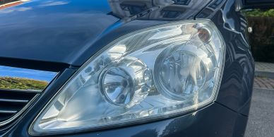 Close-up of a car's front headlight and bumper.