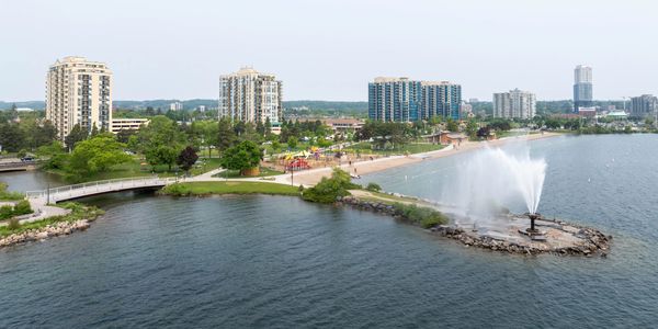 City waterfront with fountain, beach, and high-rise buildings.