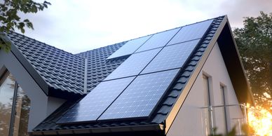 Solar panels installed on a modern house roof at sunset.