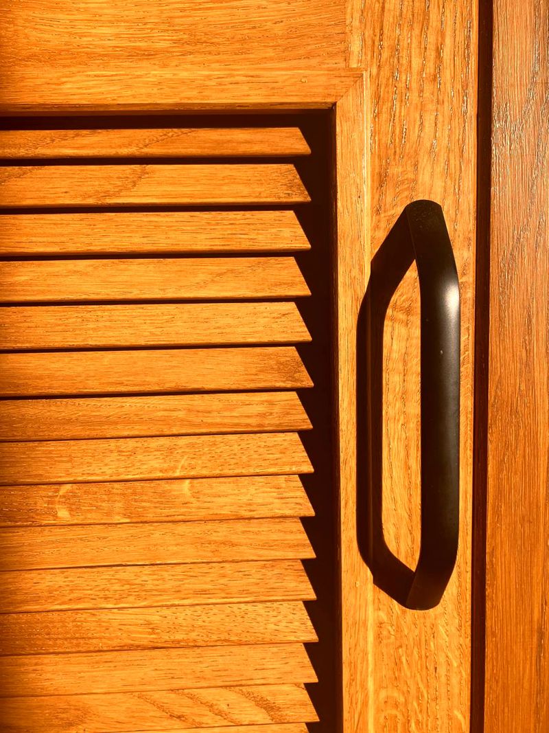 Modern oak wood wardrobe door with black handle and shutters