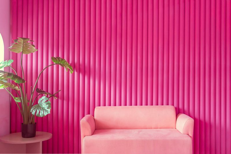 Modern living room apartment featuring a comfortable pink armchair with contemporary pink wall and stylish home decor