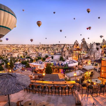 cappadocia turkey Hot air balloons float over a scenic town at sunset with unique rock formations, holiday package for turkey
