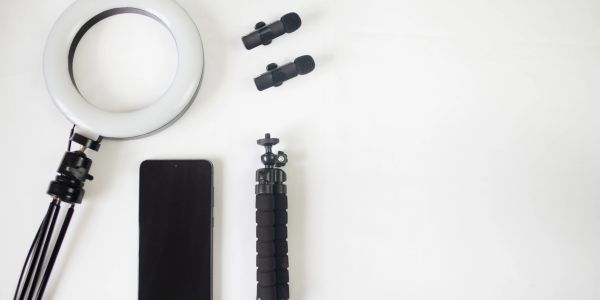 Flat lay of video recording tools on a white surface.