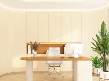 Minimalist office space with wooden desk and green plants.
