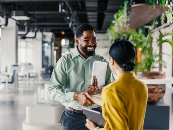 Two professionals shaking hands in an office.