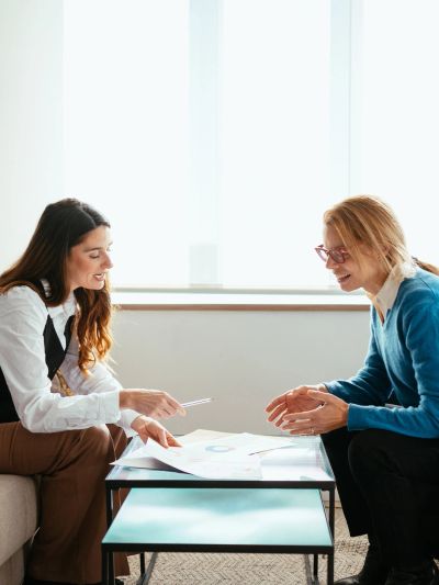 Two women discussing documents at a table.