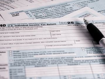 2025 U.S. Individual Income Tax Return forms with a pen.